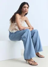 Pantalon wide leg de denim suave, color azul claro, con tiro medio, cierre frontal de cremallera y botón, detalle de pinzas y bolsillos laterales.