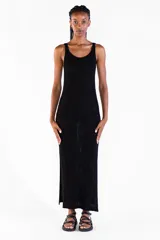 Vestido largo negro de punto con hilo lurex brillante, sin mangas, con escote redondo y aberturas laterales.
