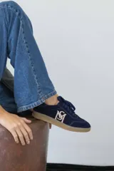 Championes de gamuza color borgoña, beige y naranja con cordones.