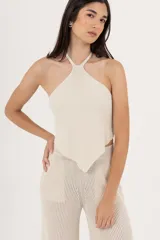 Top de tejido de punto color crema, con cuello halter y espalda descubierta.