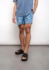 Short de baño celeste con estampado de hojas azules.