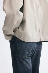 Pantalón jean de cinco bolsillos en denim de algodón con lavado azul oscuro, cintura clásica y corte de pierna recta.