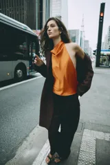 Abrigo largo de Zara confeccionado en hilatura con lana, de color marrón oscuro. Cuenta con cuello solapa, manga larga, bolsillos de vivo en el delantero y cierre frontal con dos botones.
