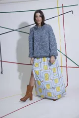 Pollera larga de terciopelo estampado con diseño geométrico en tonos celeste y amarillo. Tiene corte evasé, tajo lateral y cintura elastizada.