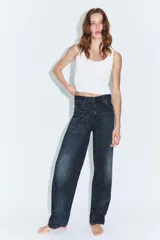 Jeans de tiro medio con diseño tipo balloon, cinco bolsillos y bajo ajustable con trabilla y botones. Cierre frontal con cremallera y botón metálico.