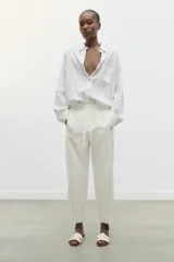 Sandalia plana dorada de piel con tiras cruzadas en la parte delantera.