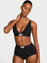 Bralette negro sin forro y sin aro, con escote en V profundo y silueta triangular. Cuenta con tirantes ajustables, detalles de cristales en toda la prenda y un parche brillante con logotipo de diamantes de imitación en la banda inferior.