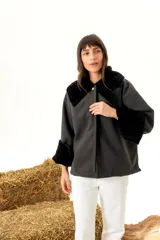 Sobre camisa oversize de paño de lana color gris oscuro con cuello y puños de piel sintética negra. Cierre frontal con un botón dorado.