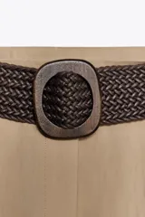 Bermuda de tiro alto color azul marino, con pinzas delanteras, bolsillos laterales y cinturón trenzado color marrón.