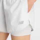 Short deportivo New Balance 2 en 1, color gris, con calza interna integrada, cintura elástica y aberturas laterales. Cuenta con tecnología NB DRY de secado rápido y logo reflectante.