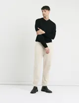 Sweater de punto con escote en V y manga larga, con puños y ruedo acanalados.
