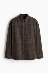 Camisa de sarga de algodón marrón con estampa de cuadros, cuello americano, cierre frontal de botones, manga larga con puños abotonados y bolsillo en el pecho.
