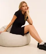 Vestido corto negro de rib de algodón, con cuello redondo y mangas cortas.