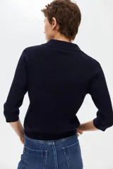 Top en punto acanalado de manga tres cuartos, color azul marino, con cuello polo y tapeta corta de botones.