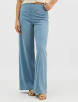 Jegging de denim azul oscuro con silueta estilo palazzo, tiro alto y pierna amplia, con pretina ancha elástica y sin bolsillos frontales.