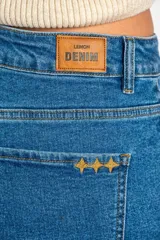 Short de denim azul de tiro medio, con bolsillos delanteros y traseros, cierre de botón y cremallera, y botamangas con dobladillo.