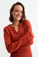 Vestido corto de tejido de punto color beige, manga larga y cuello polo con escote en V.