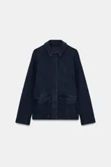 Chaqueta de estilo utilitario confeccionada en algodón con efecto lavado. Presenta cuello solapa, cierre frontal con botones ocultos bajo solapa, manga larga y bolsillos delanteros con solapa.