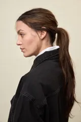 Sobrecamisa de denim de calce amplio y color azul, con cuello clásico, cierre frontal con broches metálicos y bolsillos delanteros con solapa.