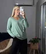 Sweater de punto color bordó con escote en V y detalle de strass aplicado en la parte frontal. Presenta mangas largas y corte holgado.