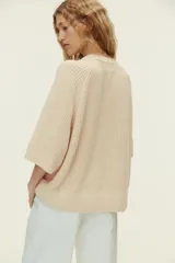Top de punto acanalado con cuello redondo, mangas al codo de corte raglán y diseño oversized. Presenta terminaciones acanaladas en cuello, puños y bajo.