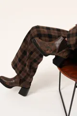 Bota tipo chelsea de cuero con acabado texturizado efecto desgastado en color chocolate. Presenta paneles laterales elásticos, suela de plataforma y taco cuadrado robusto en color negro.