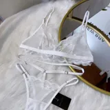 Set de lencería de cuatro piezas compuesto por bralette de encaje, tanga regulable, portaligas y ligas. Confeccionado en microtul y encaje con transparencias.