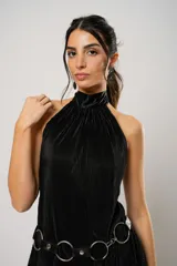 Vestido corto negro plisado con cuello halter y espalda baja. Incluye cinturón de cuero con aros metálicos.
