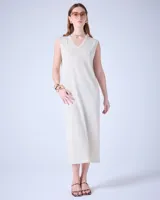 Vestido largo de tejido de punto color crudo, con textura metalizada, cuello escote en V y tajos laterales.