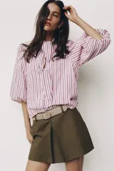 Falda pantalón de tiro medio en color verde militar, con diseño de pliegue delantero y cierre lateral con cremallera oculta. Incluye un cinturón ancho en tono tostado con hebilla metálica ovalada.