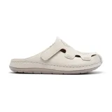 Zueco casual color blanco hueso, con capellada de cuero sintético con perforaciones decorativas, tira ajustable con velcro y plantilla anatómica.