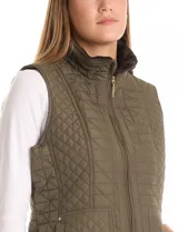 Chaleco capitoneado color verde oliva, con cuello alto, cierre frontal completo y bolsillos laterales. El interior está completamente forrado en símil piel para mayor calidez.