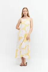 Maxi vestido amarillo con estampado floral blanco y rosa, de tirantes finos y corte holgado.