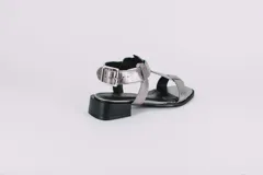 Sandalias plateadas de cuero con tiras finas y suela plana.