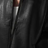 Campera negra de cuero sintético con cuello de sherpa y cierre frontal con cremallera.