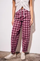 Jean baggy de tiro medio con estampado de rombos en tonos violeta y bordó.