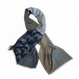 Pashmina de textura suave con diseño de paneles combinados que alterna estampados de caballos y patrones geométricos de líneas en zigzag. Presenta bordes con flecos cortos.