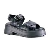 Sandalias de plataforma color rosa con textura tipo piel de cocodrilo, con dos tiras anchas cruzadas sobre el empeine y tira con hebilla al tobillo.