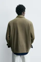 Polo de manga larga con cuello solapa y cierre frontal de cremallera. Presenta un diseño de corte regular con acabado en rib en los puños y un efecto lavado en la tela.