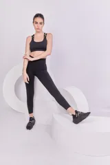 Top deportivo negro con espalda cruzada, elástico inferior y tiras regulables con logo Basset.