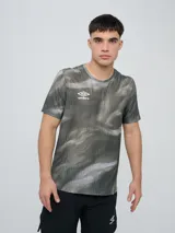 Remera deportiva Umbro modelo Niso, de manga corta y cuello redondo, con estampado abstracto en tonos negro y gris, y logo de la marca impreso en el pecho.