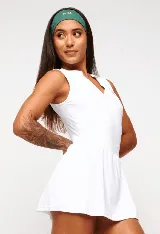 Vestido deportivo negro sin mangas, con escote en V y logo estampado en el pecho. Falda corta con short interno y bolsillos laterales. Incluye protección UV50+.