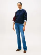 Sweater de punto con diseño de trenzas, cuello redondo y detalle de botones dorados en el hombro. Presenta terminaciones acanaladas en puños y dobladillo, con logo bordado en el pecho.