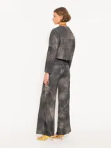 Pantalón de cuero ovino distress color negro, de silueta ancha con recortes diagonales y curvos en delantero y espalda, bolsillos frontales y bolsillos plaqué en la parte trasera.