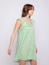 Vestido corto de viscosa con estampado a rayas verticales en tonos celeste, azul y blanco. Sin mangas, con volados en los hombros y escote cuadrado con ribete azul marino.