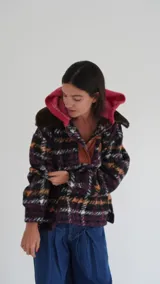 Buzo canguro oversize con capucha y cuello alto, confeccionado con paños de lana estampados.