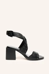 Sandalia de cuero vacuno negra con tiras cruzadas y tachas metálicas. Taco ancho de 6,5 cm.