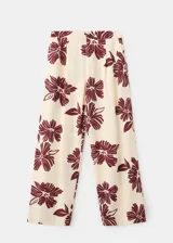 Pantalón de corte regular y tiro medio, con diseño fluido y estampado floral en color bordó sobre fondo beige.