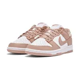 Championes Nike Dunk Low con diseño bicolor en blanco y rosa viejo. Presentan una silueta clásica de perfil bajo, con paneles de cuero, perforaciones en la puntera para mayor ventilación y suela de goma resistente.