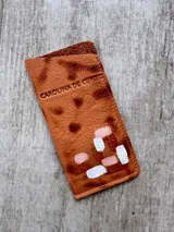 Portalentes de cuero color marrón tierra, de diseño artesanal con detalles pintados a mano en tonos rosados y blancos en la parte inferior. Cuenta con el logo de la marca grabado en la parte superior.